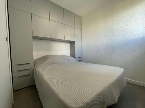 - une chambre avec un lit blanc et des armoires blanches dans l'établissement Appartement 2 pièces avec loggia et piscine à 100m de la plage - Le Grau-du-Roi - FR-1-250-250, au Grau-du-Roi