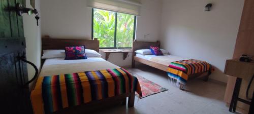 um quarto com duas camas e uma janela em Fincas Panaca Herreria 1 - San Judas em Quimbaya