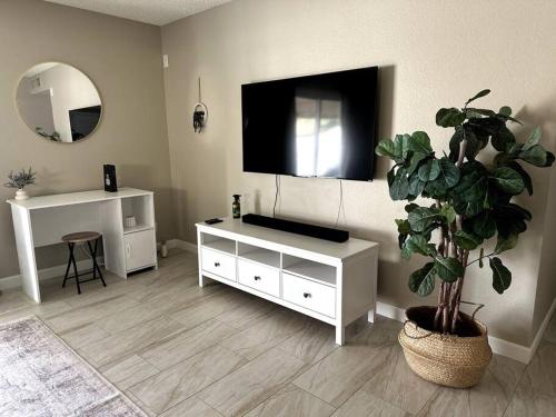 a living room with a tv and a potted plant at Cozy Bohemian Home w/ Hot Tub in Mesa in Mesa