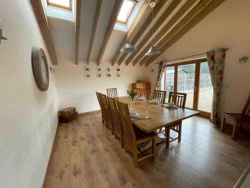 a dining room with a wooden table and chairs at Charming Norfolk Barn Conversion in Barnham Broom in Norwich