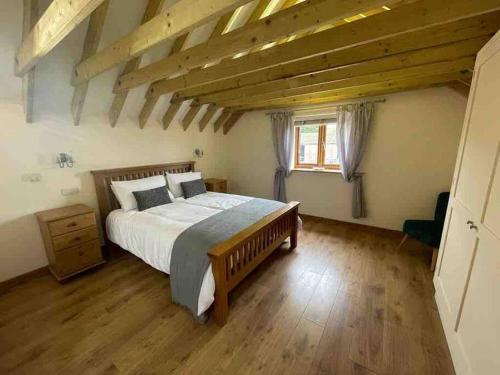 a bedroom with a large bed and a wooden floor at Charming Norfolk Barn Conversion in Barnham Broom in Norwich