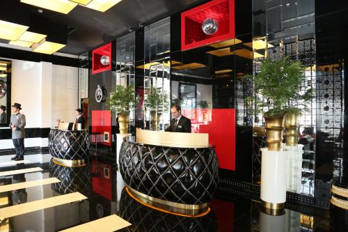 a lobby with two black and gold vases with plants at Ramada Hotel & Suites by Wyndham Istanbul- Sisli in Istanbul