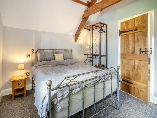 a bedroom with a bed and a wooden door at The Dairy in Skenfrith