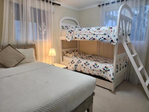 een slaapkamer met 2 stapelbedden en een ladder bij 2 bedrooms, 2 bathrooms, pool and near from the beach in Juan Dolio