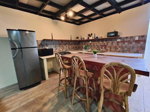 a kitchen with a refrigerator and a table with chairs at Casa completa en apaneca El salvador in Apaneca
