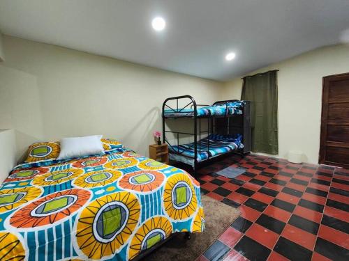a bedroom with a bed and a checkered floor at Casa completa en apaneca El salvador in Apaneca
