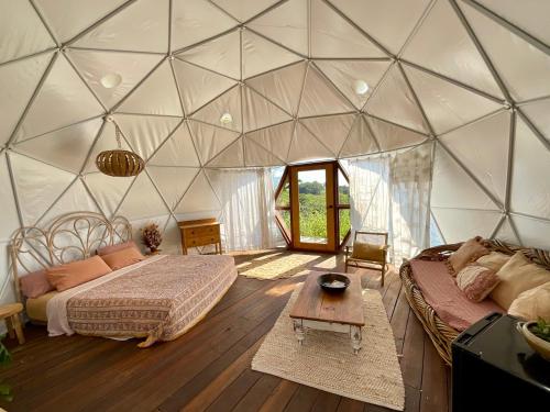 a room with two beds and a table in a tent at Golden Domes in Cootharaba
