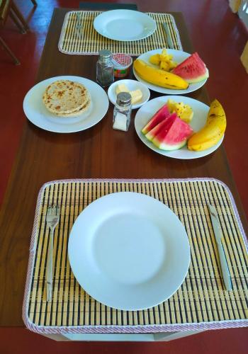 a table with plates of food and fruit on it at Once in Ella in Ella