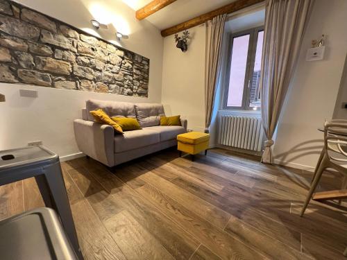 un soggiorno con divano e parete in pietra di LaLucia Luxury Suite Lake Como ad Argegno