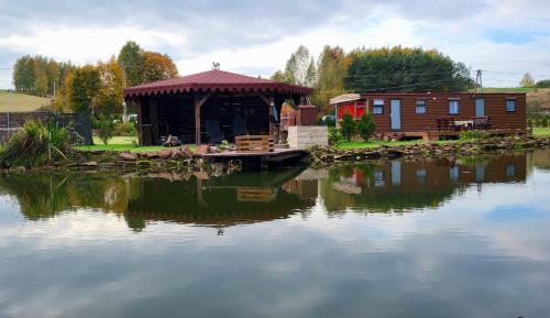 a cabin on the water next to a lake at Świętokrzyska Italia in Włochy