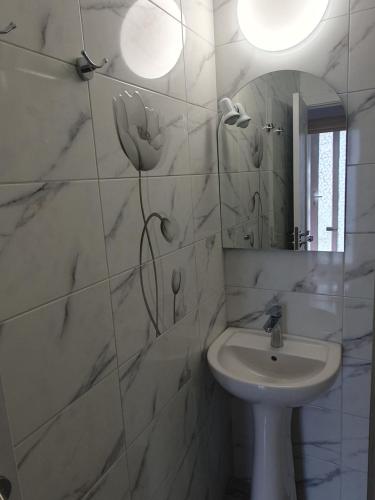Baño blanco con lavabo y espejo en Vila Sunset 2, en Galaţi