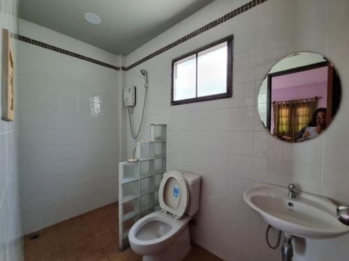 a bathroom with a toilet and a sink and a mirror at Sawasdee Sichang Resort in Ban Tha Thewawong