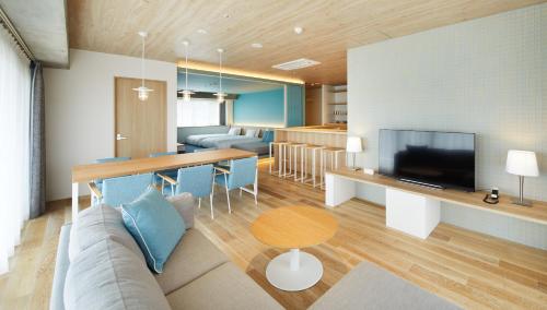 a living room with a couch and a table with a television at BEB5 Okinawa Seragaki by Hoshino Resorts in Onna