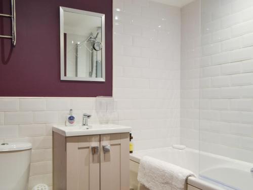 a bathroom with a sink and a tub and a toilet at Willow Cottage in Cockermouth