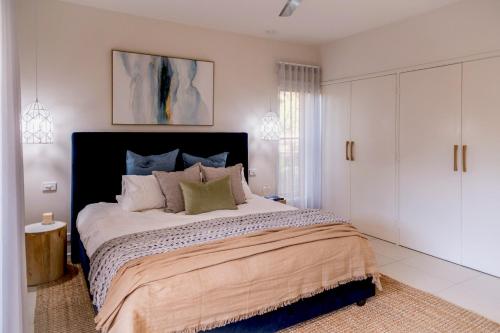 a bedroom with a large bed with white cabinets at Torquay Bliss Retreat with Sauna and Hot Tub in Torquay