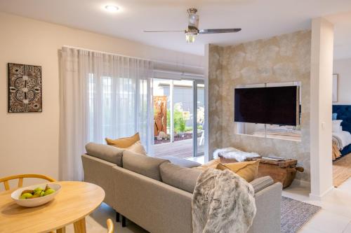a living room with a couch and a tv at Torquay Bliss Retreat with Sauna and Hot Tub in Torquay