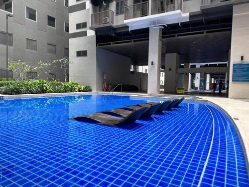 馬尼拉的住宿－Hygge Suite @ Moa complex near Naia, Ccp , Dfa，大楼内带躺椅的大型游泳池
