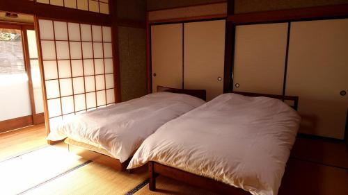 HOSHIYAMA A extra for pets - Vacation STAY 07884v في فوجينوميا: غرفة نوم بسرير ذو شراشف بيضاء