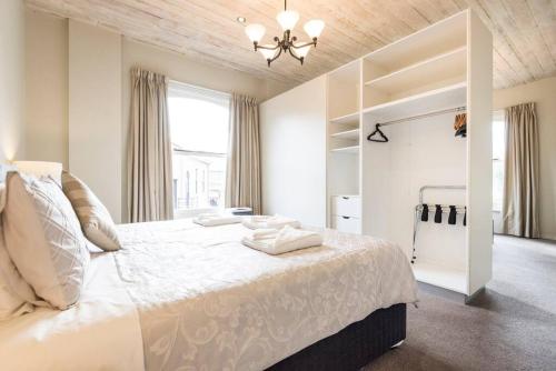 荷伯特的住宿－Hobart CBD Premium Apartment, 3 mins to waterfront，白色卧室配有一张大床和吊灯