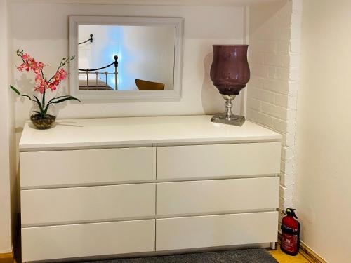 a dresser with a mirror and a vase on it at Cobble Cottage in Cramond