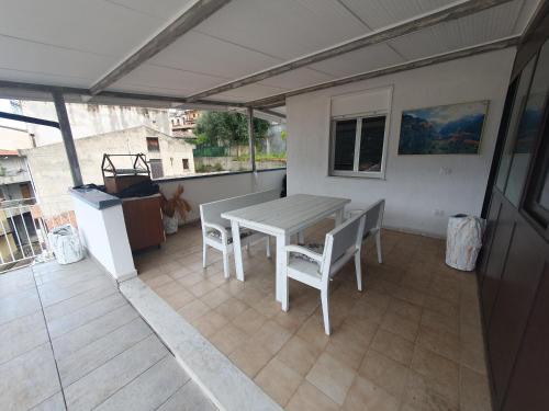 a patio with a table and chairs on a balcony at Matilde Holiday-home in SantʼAngelo di Brolo