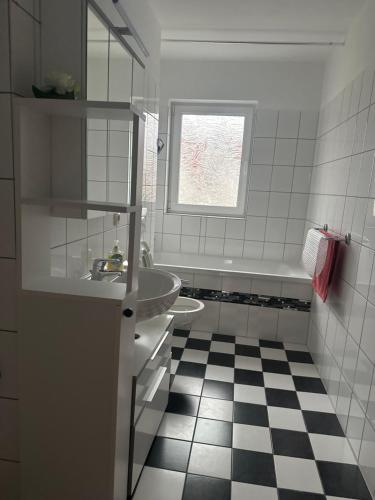 a white bathroom with a sink and a bath tub at Käthe-Kollwitz - Straße 54, F3 in Altenburg