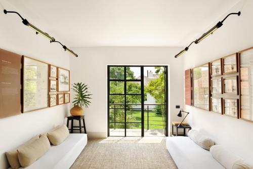 uma sala de estar com um sofá branco e uma janela em Satyagraha House em Joanesburgo