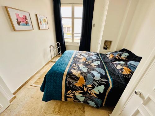 - une chambre avec un lit doté d'un couvre-lit coloré dans l'établissement Centre San Peire Les Issambres, aux Issambres