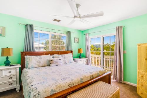 a bedroom with a bed and two windows at Key Lime Time in Cudjoe Key