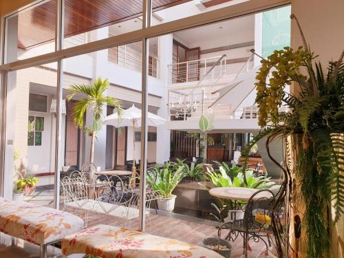 an indoor patio with tables and chairs and plants at Green Hotel and Resort in Khon Kaen