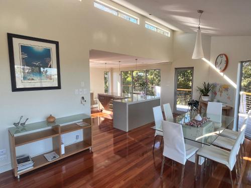 a dining room and living room with a table and chairs at Harbour Lookout in Strahan