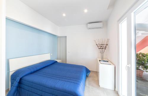 Un dormitorio con una cama azul y una ventana en Casa Yucca, en Isquia