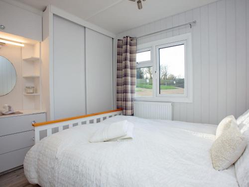 牛頓阿伯特的住宿－The Retreat 8-uk36701，白色的卧室设有一张大床和一个窗户