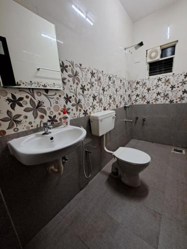 D'souza's Guest House في Tivim: حمام مع حوض ومرحاض