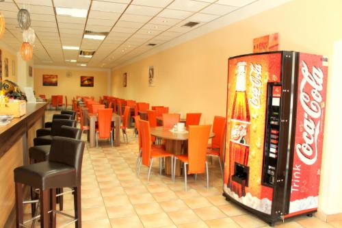 a restaurant with a coke machine and tables and chairs at Alper Hotel am Potsdamer Platz in Berlin