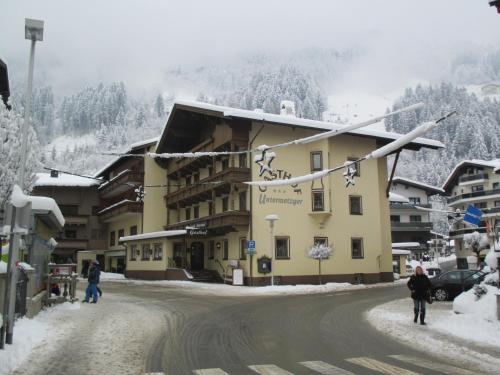a building on a snow covered street in a mountain at Hotel Untermetzger in Zell am Ziller