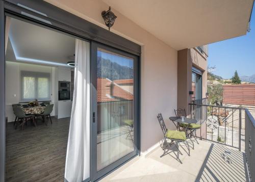 a balcony with sliding glass doors with a table and chairs at Marea DeLuxe Apartments in Kotor