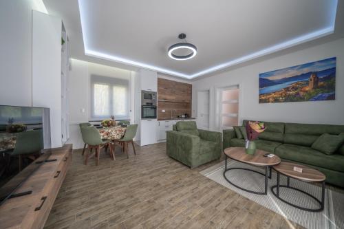 uma sala de estar com um sofá verde e uma mesa em Marea DeLuxe Apartments em Kotor