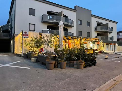 a building with a bunch of potted plants in a parking lot at Apartment Sandy Beach - 1st row at sea in Pješčana Uvala 