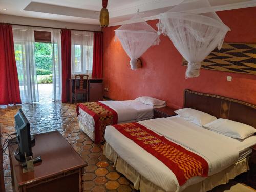 a hotel room with two beds and a television at Inside Afrika Boutique Hotel in Kigali