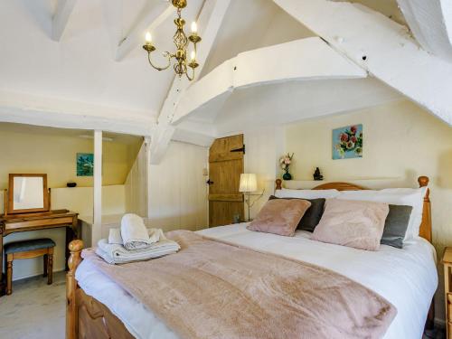 a bedroom with a large bed in a room at Honeysuckle Cottage in Axminster