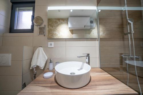 a bathroom with a large white sink and a shower at Marea DeLuxe Apartments in Kotor