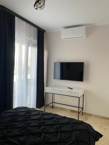 Dormitorio con TV y mesa con cama en Apartamente cu un dormitor en Timisoara
