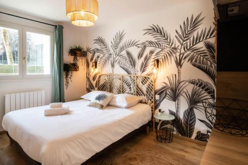 - une chambre avec un grand lit blanc et un mur de plantes dans l'établissement Acapulco romantique, à Annecy