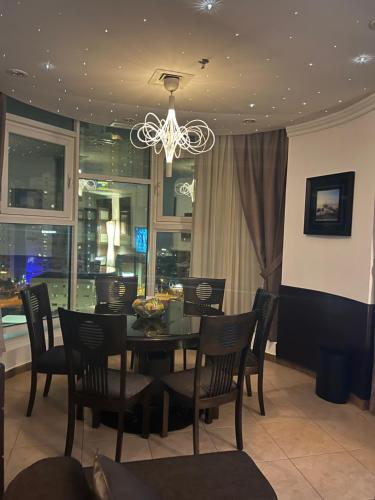 comedor con mesa, sillas y lámpara de araña en Bneid Al Gar Penthouse Entire Apartment 3 Bedroom Family Only, en Kuwait
