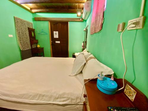 a bedroom with a bed and a table with a lamp at 彼岸古厝民宿-包棟優先--Biiann B&B in Jinning