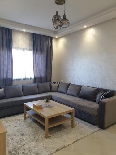 a living room with a couch and a coffee table at شقة راقية ومريحة للغاية in Tangier