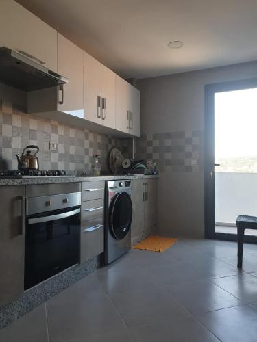 a kitchen with a washer and a dishwasher at شقة راقية ومريحة للغاية in Tangier