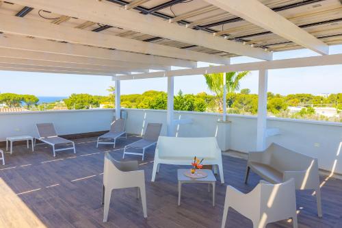 a patio with chairs and tables on a deck at Aparthotel Residences Ludovica & Valentina - Piscina Panoramica Vista Mare in Santa Maria al Bagno