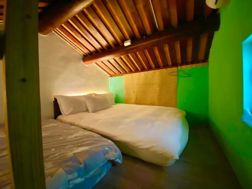 a bedroom with a bed and a green wall at 彼岸古厝民宿-包棟優先--Biiann B&B in Jinning